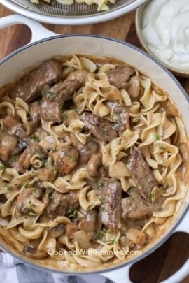 beef stroganoff with egg noodles in a white dutch oven