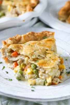 a piece of turkey pot pie on a plate garnished with a sprinkle of parsley