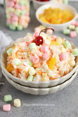 ambrosia salad in a bowl topped with a cherry