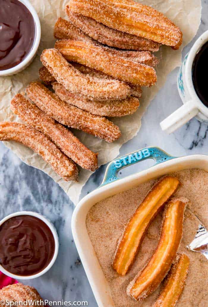 Churros being dipped in sugar