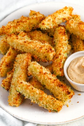 Baked crispy Zucchini fries on a plate with dip