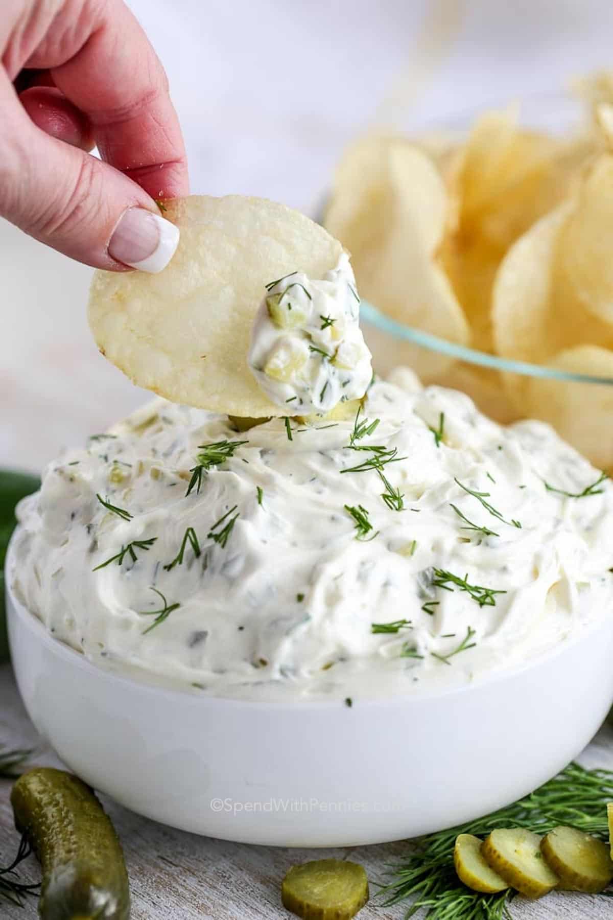 dipping a potato chip into a bowl of dill pickle dip