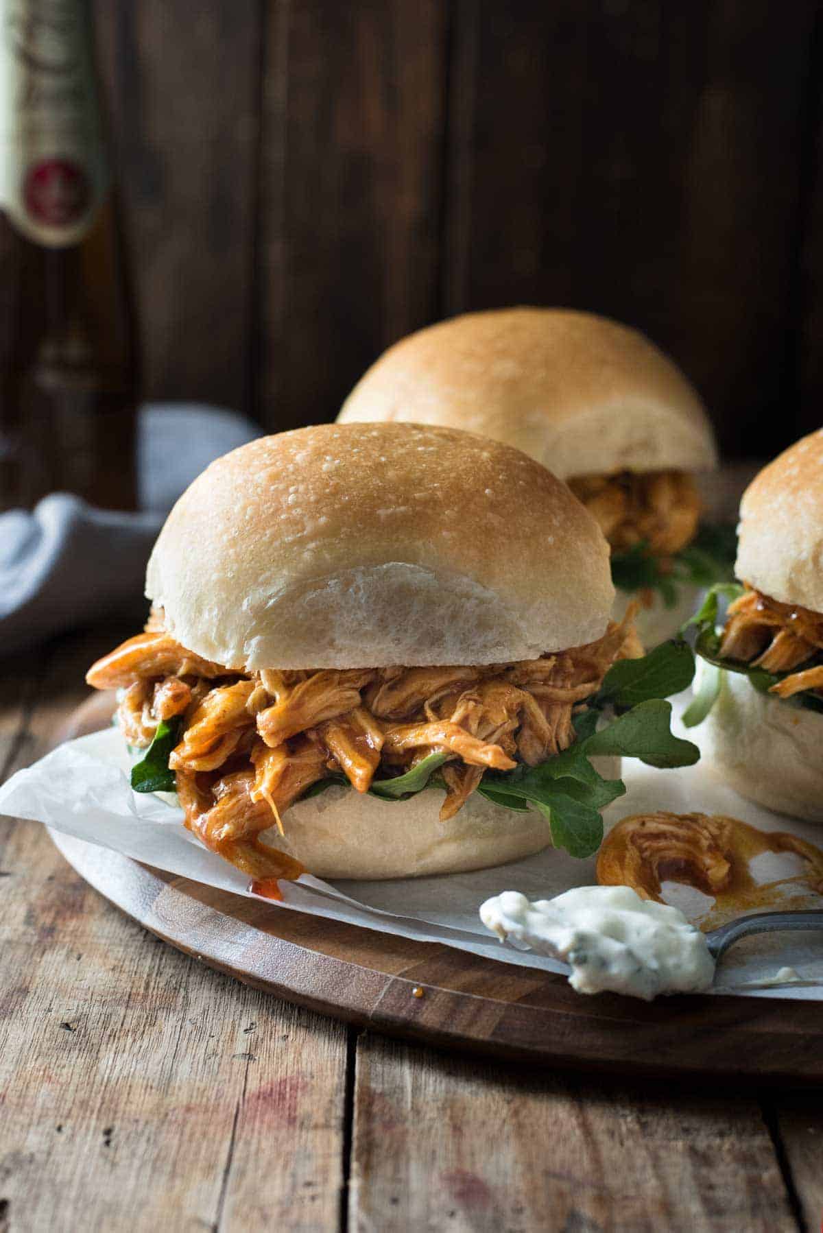 shredded buffalo chicken on a bun with lettuce