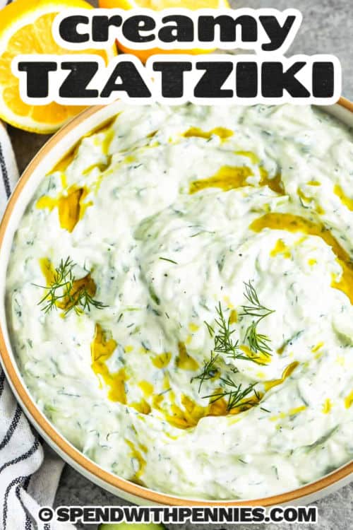 bowl of Easy Tzatziki Recipe and lemons beside it with a title