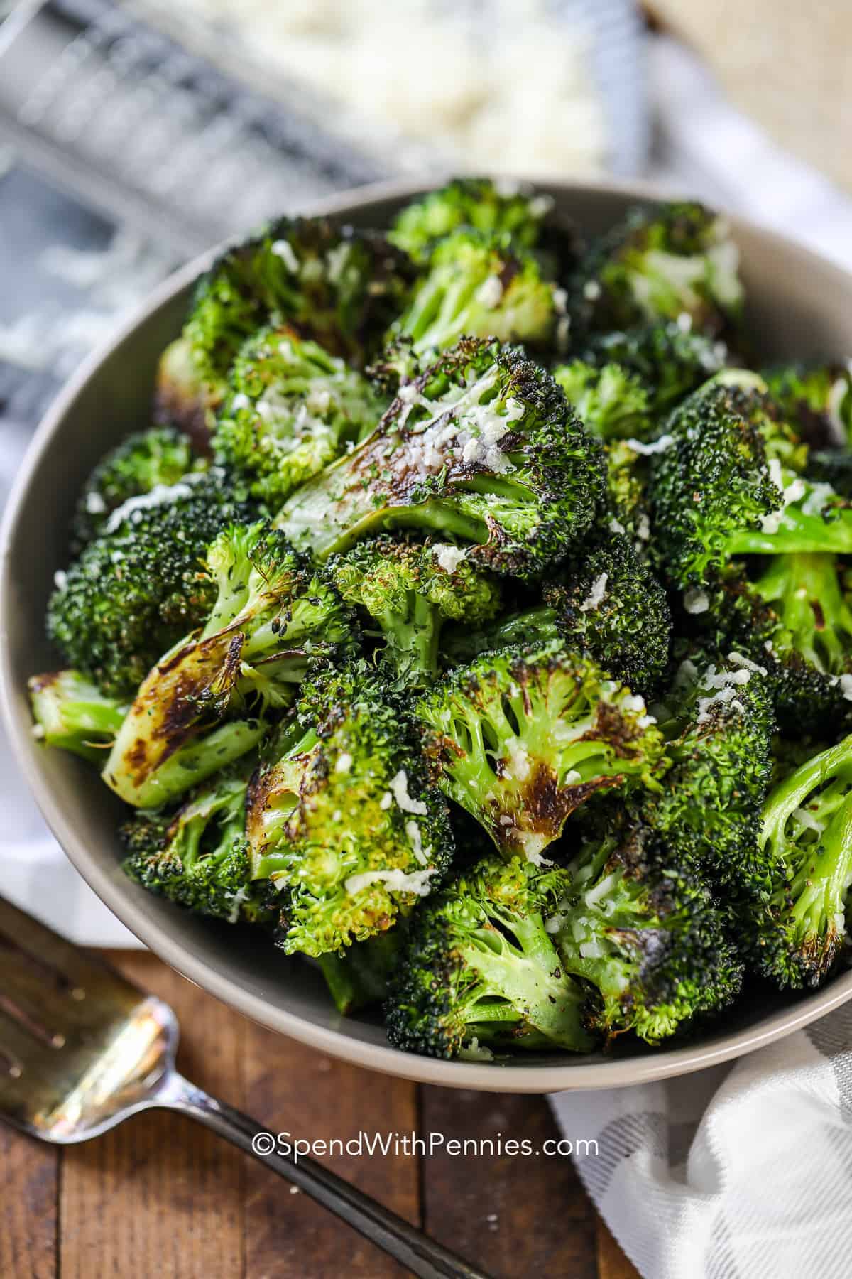 a bowl of roasted broccoli with parmesan cheese