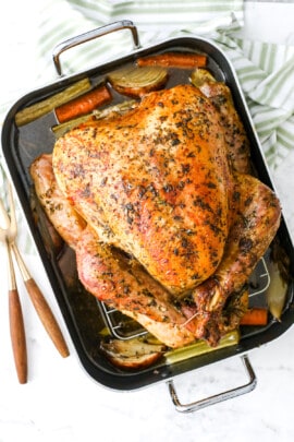 a roasted turkey in a baking pan