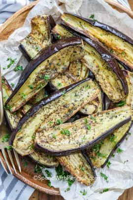 Roasted eggplant on parchment paper with a fork