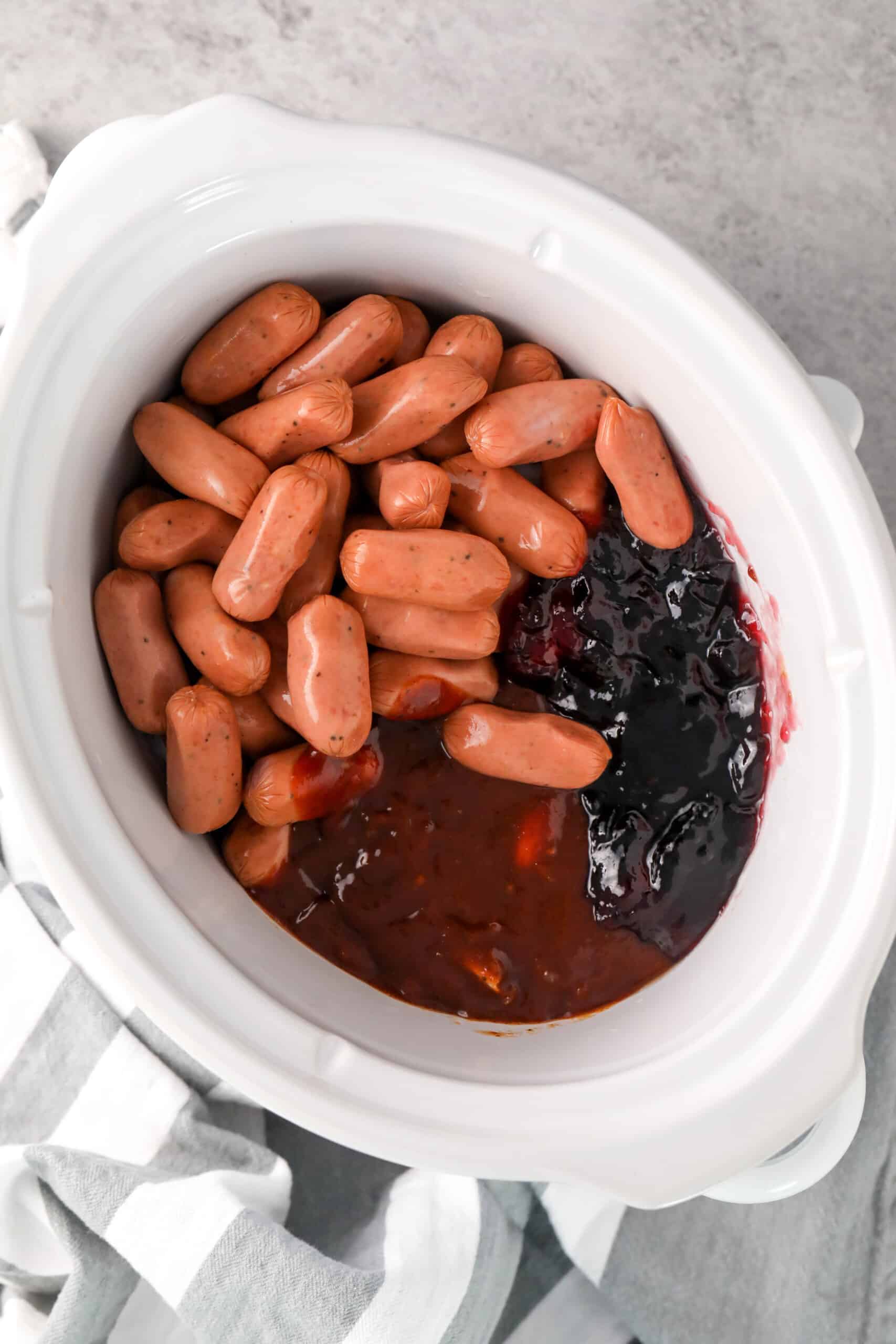 adding ingredients to pot to make Slow Cooker Little Smokies