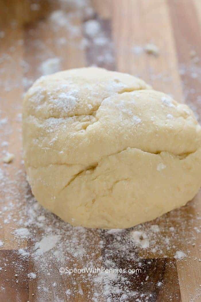 Ball of dough sprinkled with flour on a cutting board