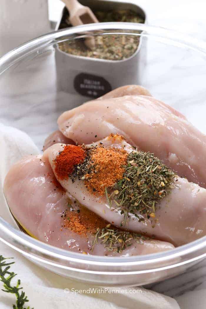 chicken breasts tossed with seasoning for baking