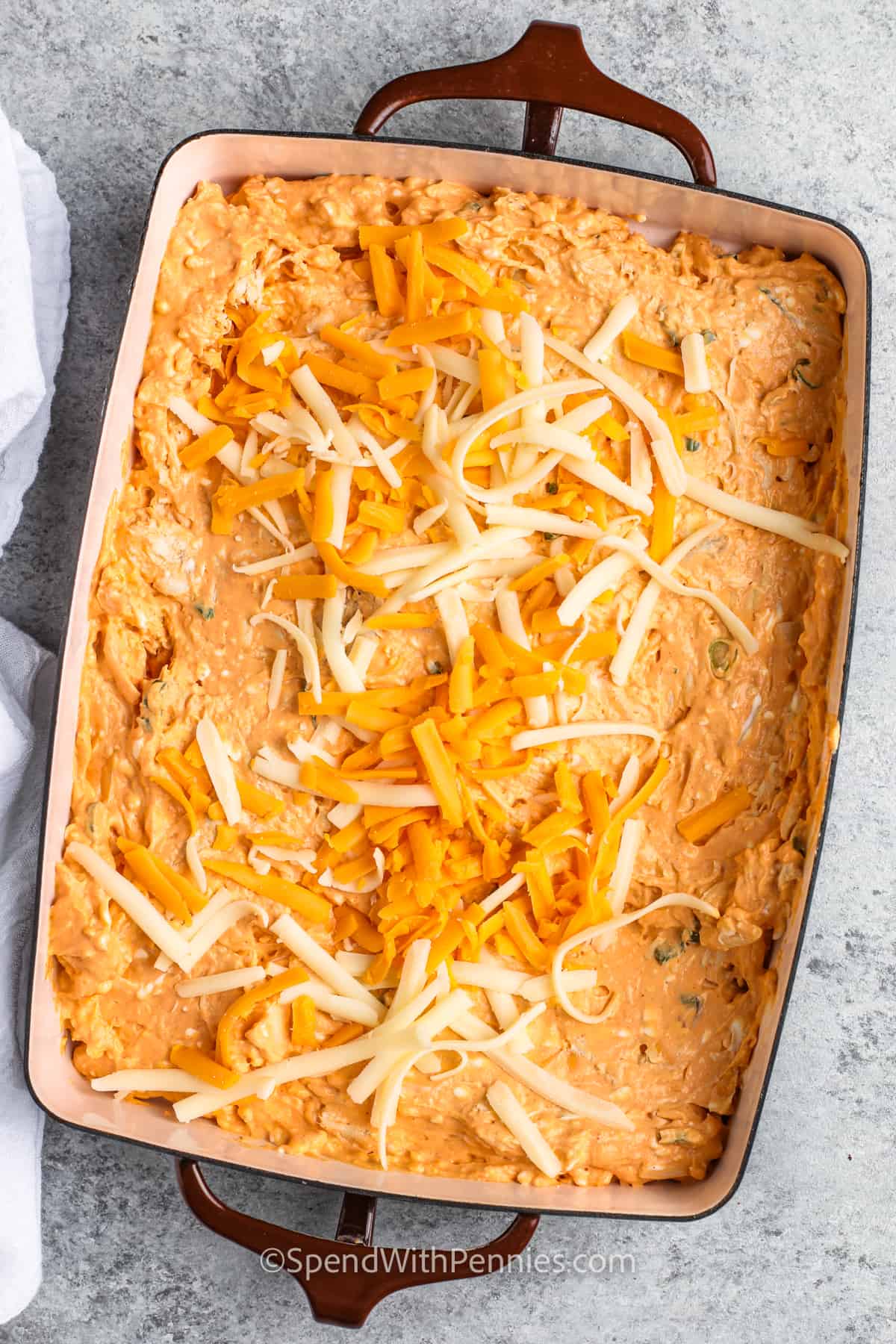 adding cheese to The Best Buffalo Chicken Dip