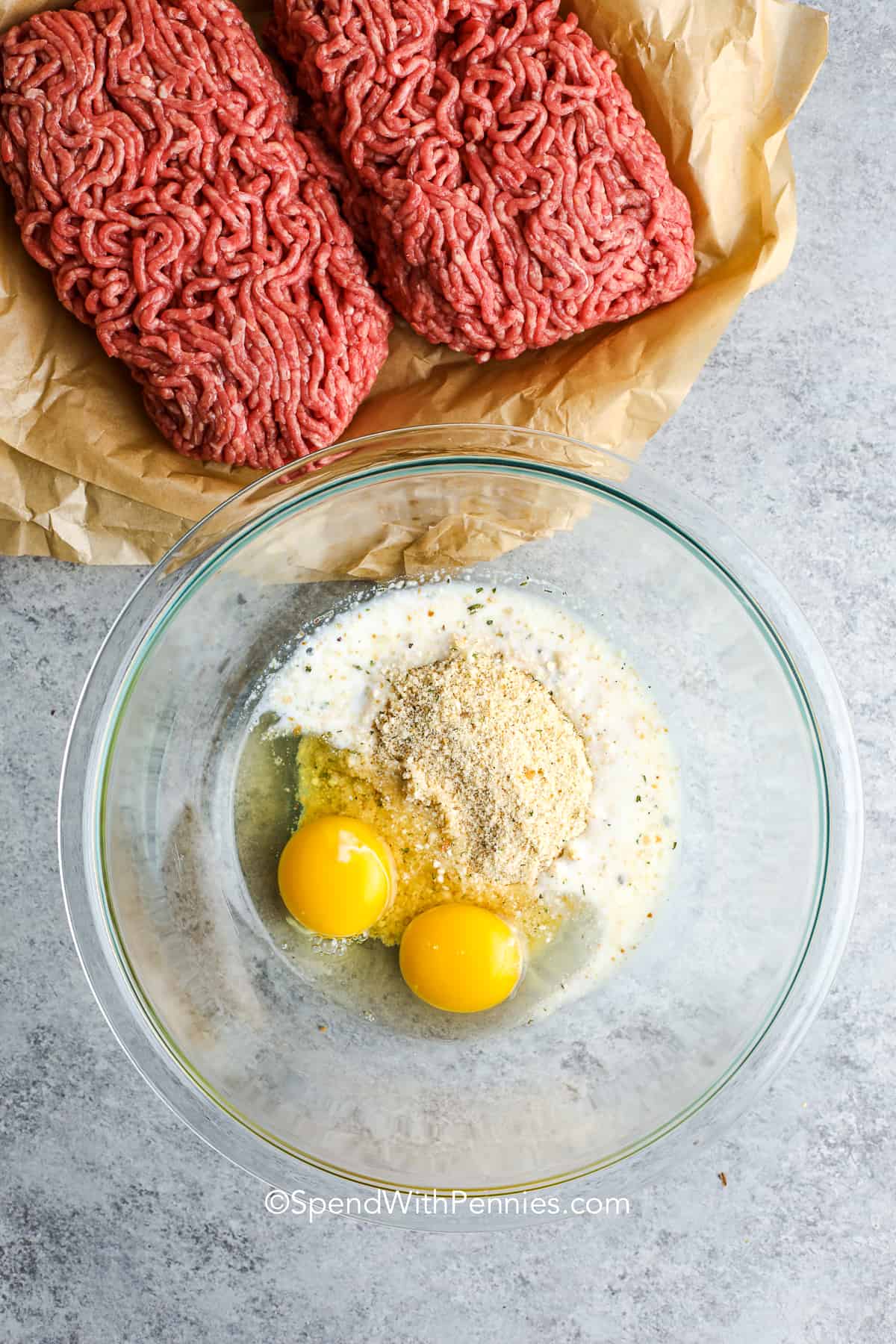 Mixing the eggs, breadcrumbs and milk to make meatloaf